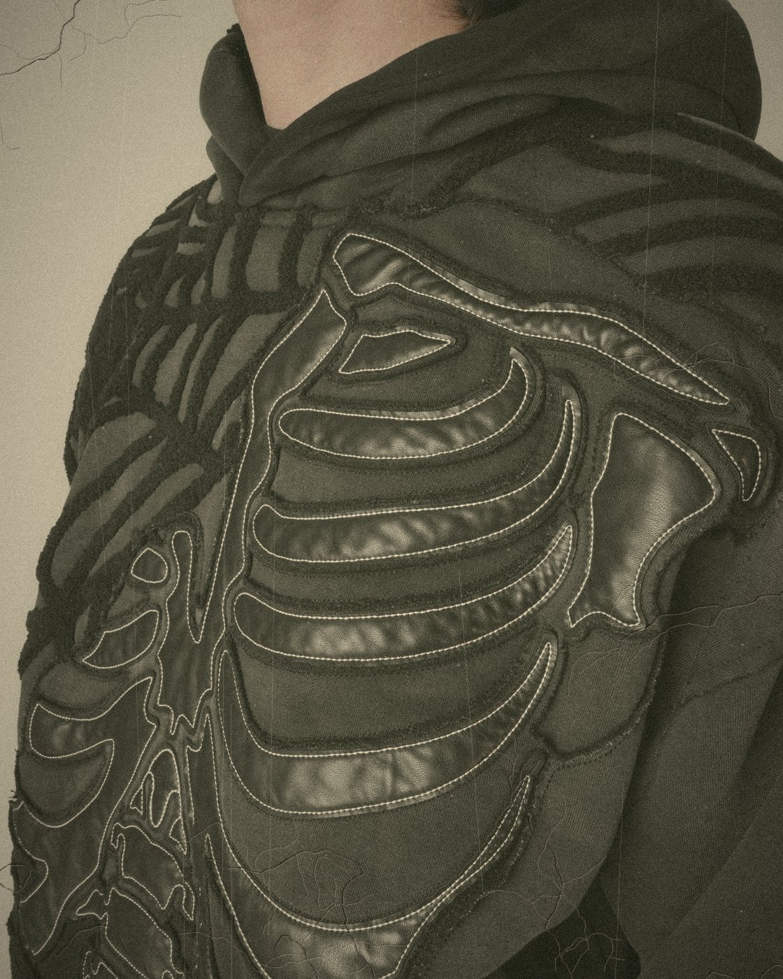 Black skeleton appliqué stitched across a black hoodie