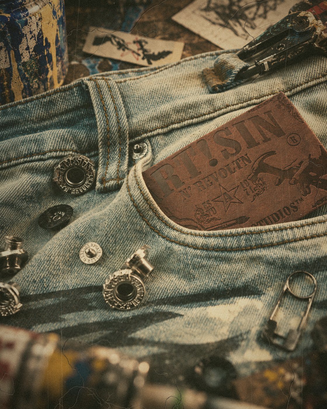 Leather ART!SIN patch and polished metal hardware on washed denim